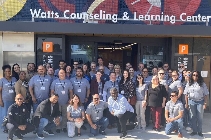 CU Impact attendees during a guided excursion to Kinecta FCU’s Watts branch, which included a visit in front of the Watts Counseling and Learning Center — which provides counseling, outreach, and educational services to surrounding communities.
