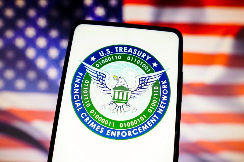 FinCEN logo on a smartphone in front of an American flag.